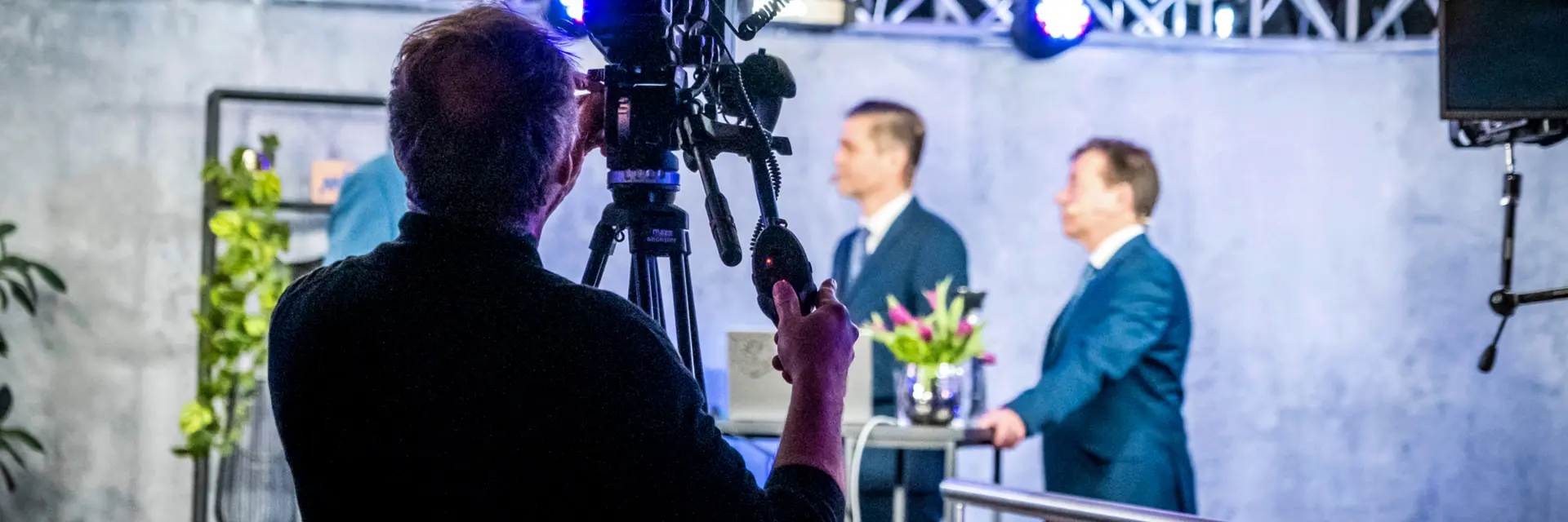 Kameramann filmt zwei Männer im Interview auf Bühne