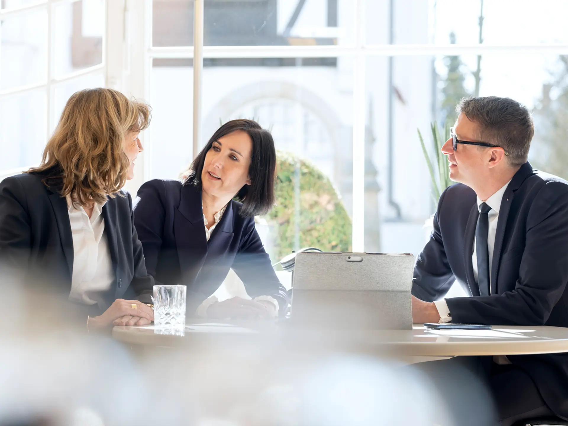 Drei Personen unterhalten sich am Tisch