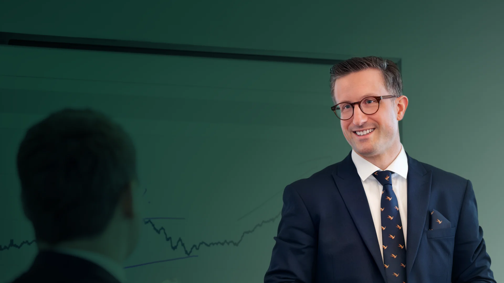 Mann im Anzug präsentiert etwas vor einer Person