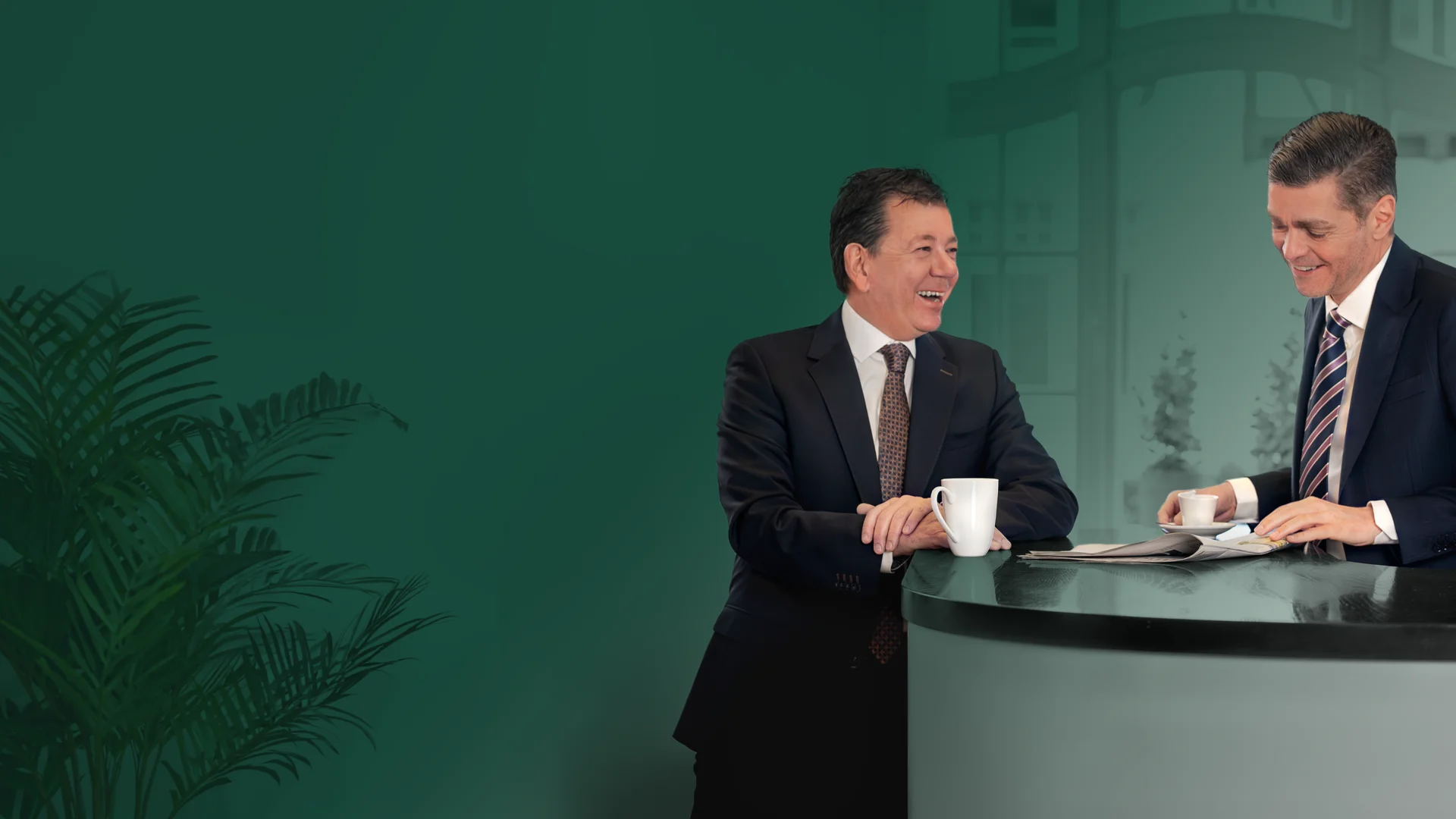 Dirk Scherz und Sebastian Kotte stehen und lachen gemeinsam, während sie eine Zeitung oder ein Heft anschauen